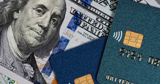 Credit cards and cash piled, division of debt during divorce concept.