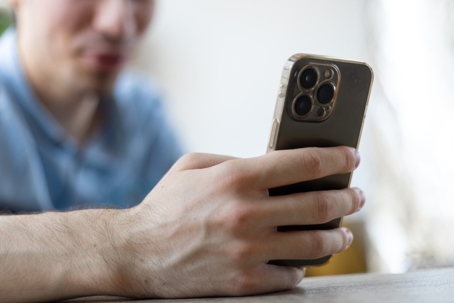 Man with a finger on the screen using a mobile phone