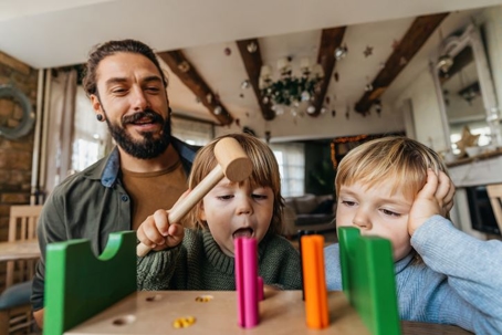 Father playing blocks with his two kids
