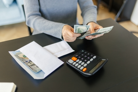 person counting money and budgeting