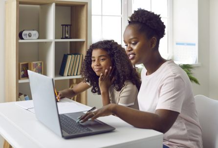 mother and daughter looking at a laptop together