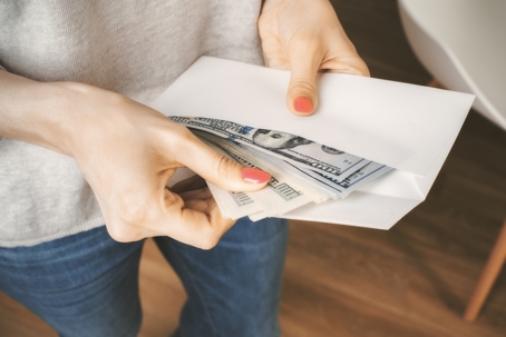 Woman holding envelope with dollars