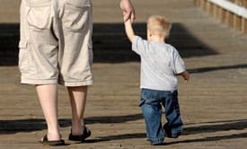 father holding son's hand as they walk