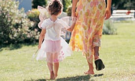 girl in costume holding mothers hand